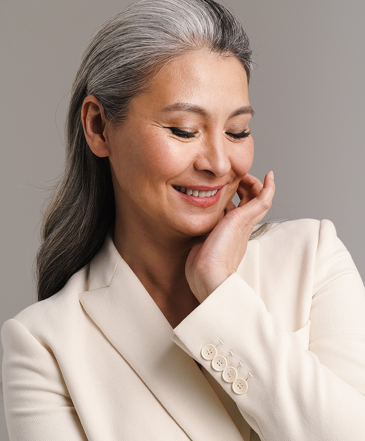 Smiling woman with gray hair and blazer.