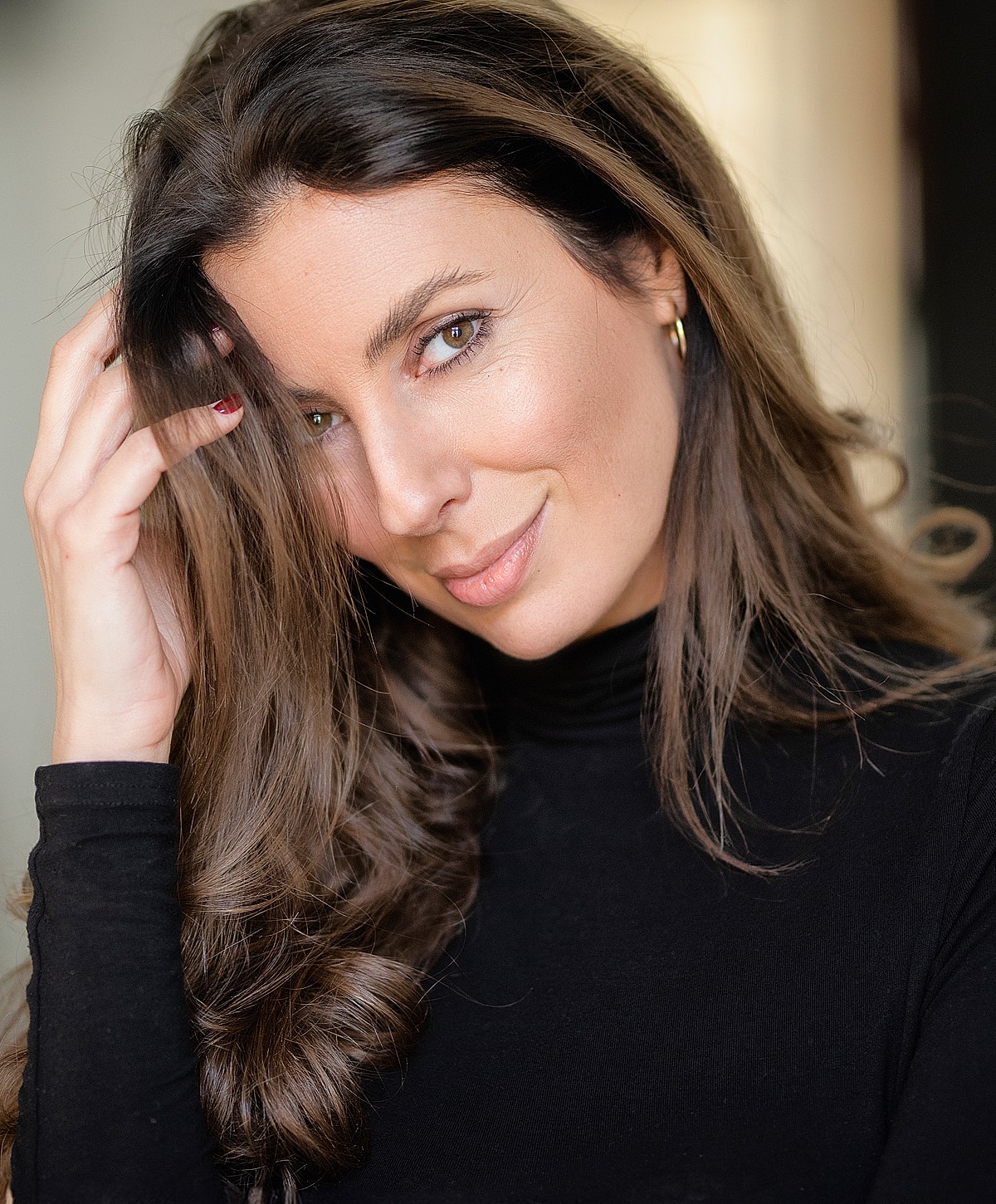 Woman with long hair smiling softly.