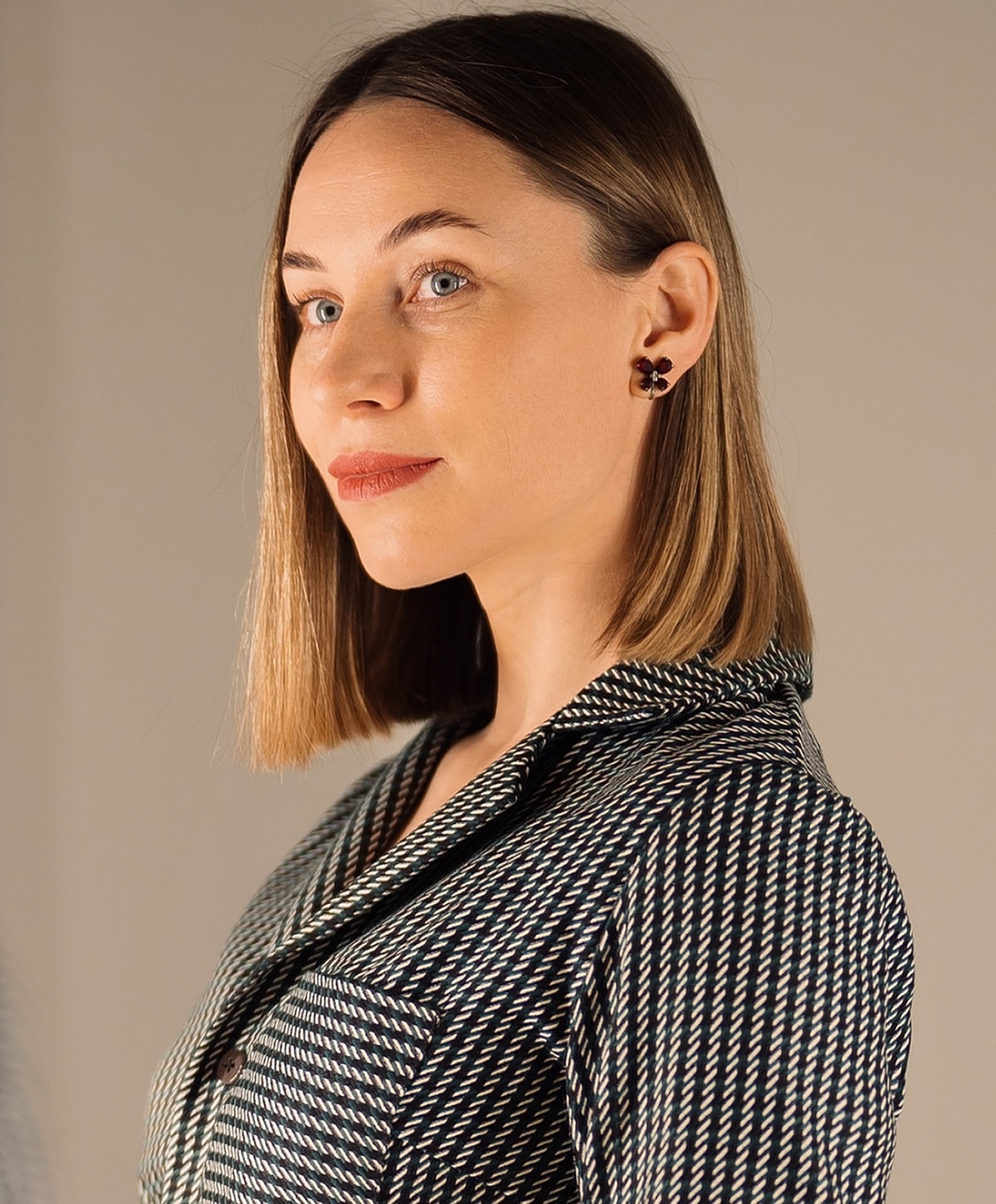 Woman with short hair in patterned jacket.
