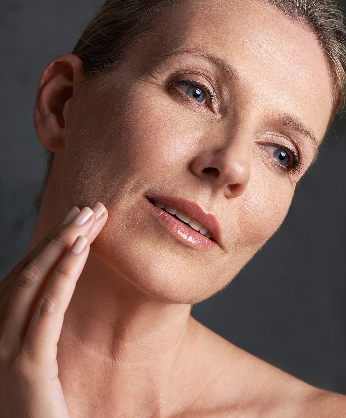Woman gently touching her face, natural beauty.