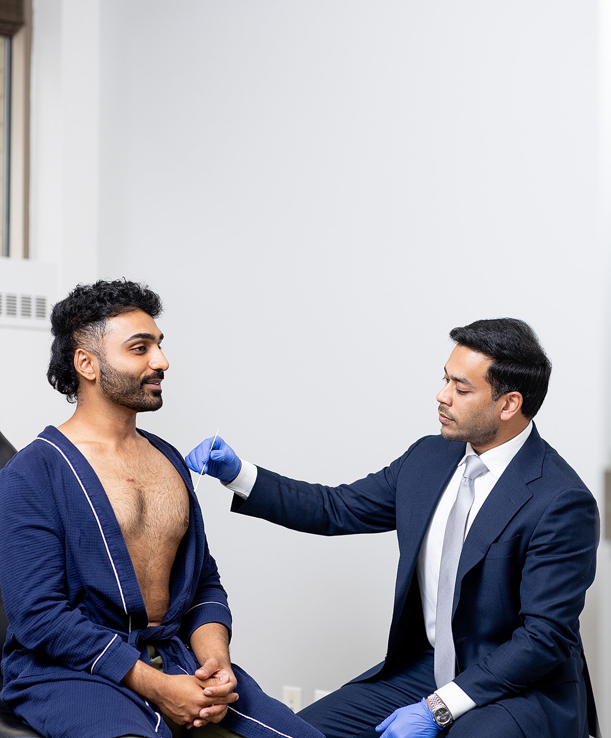 Doctor examining a patient in a clinical setting.