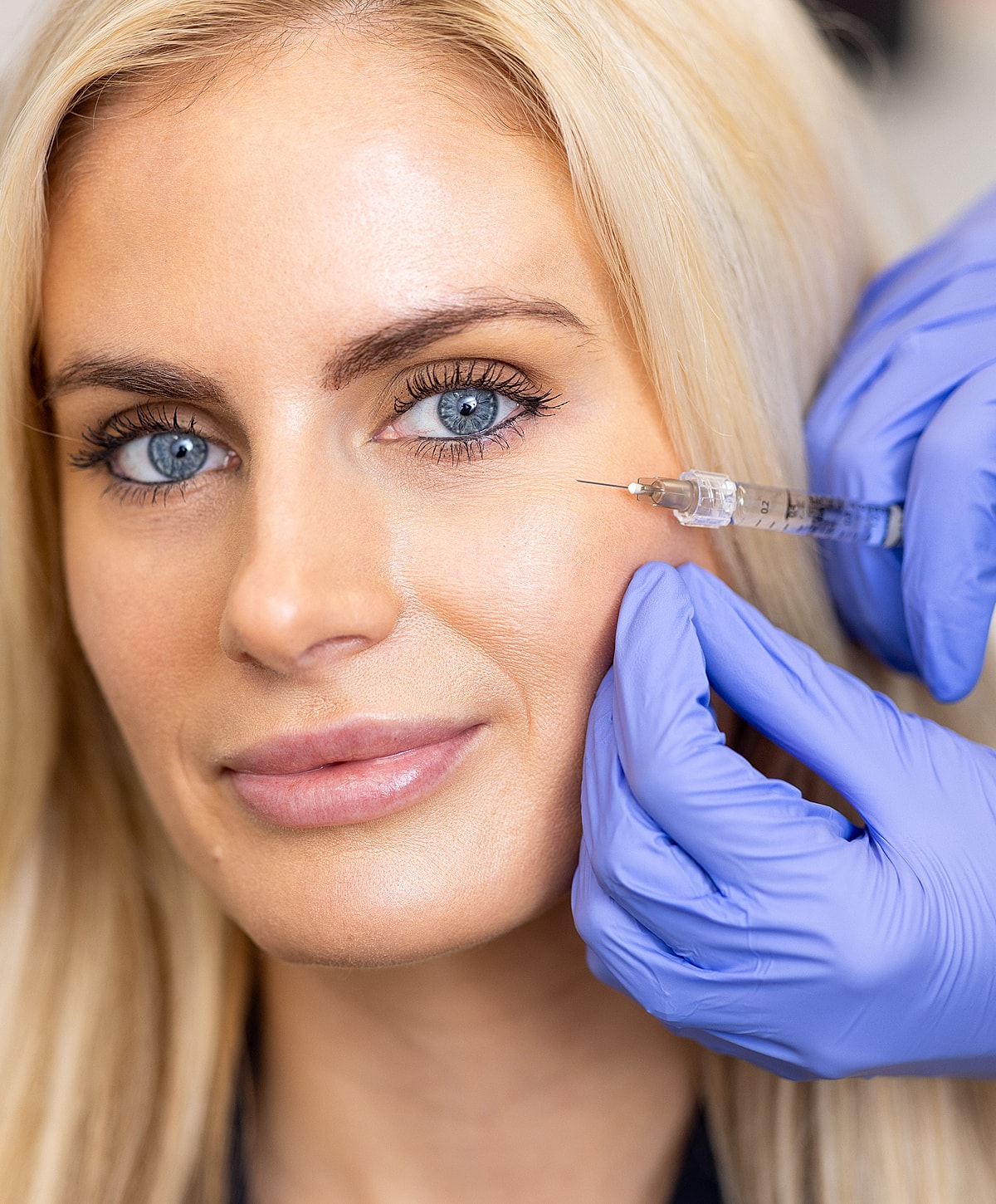 Cosmetic procedure with syringe and model.