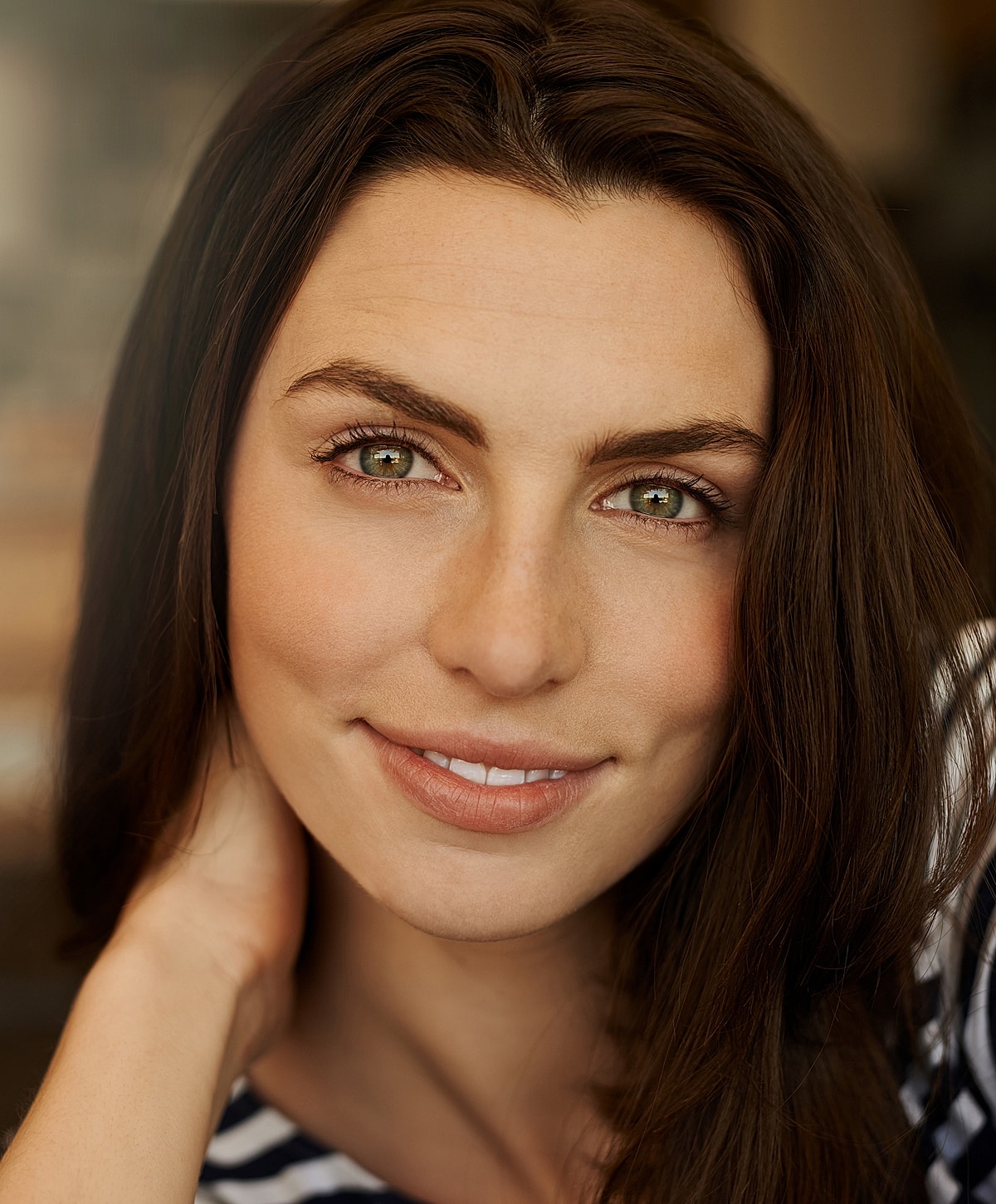 Smiling woman with dark hair and green eyes.