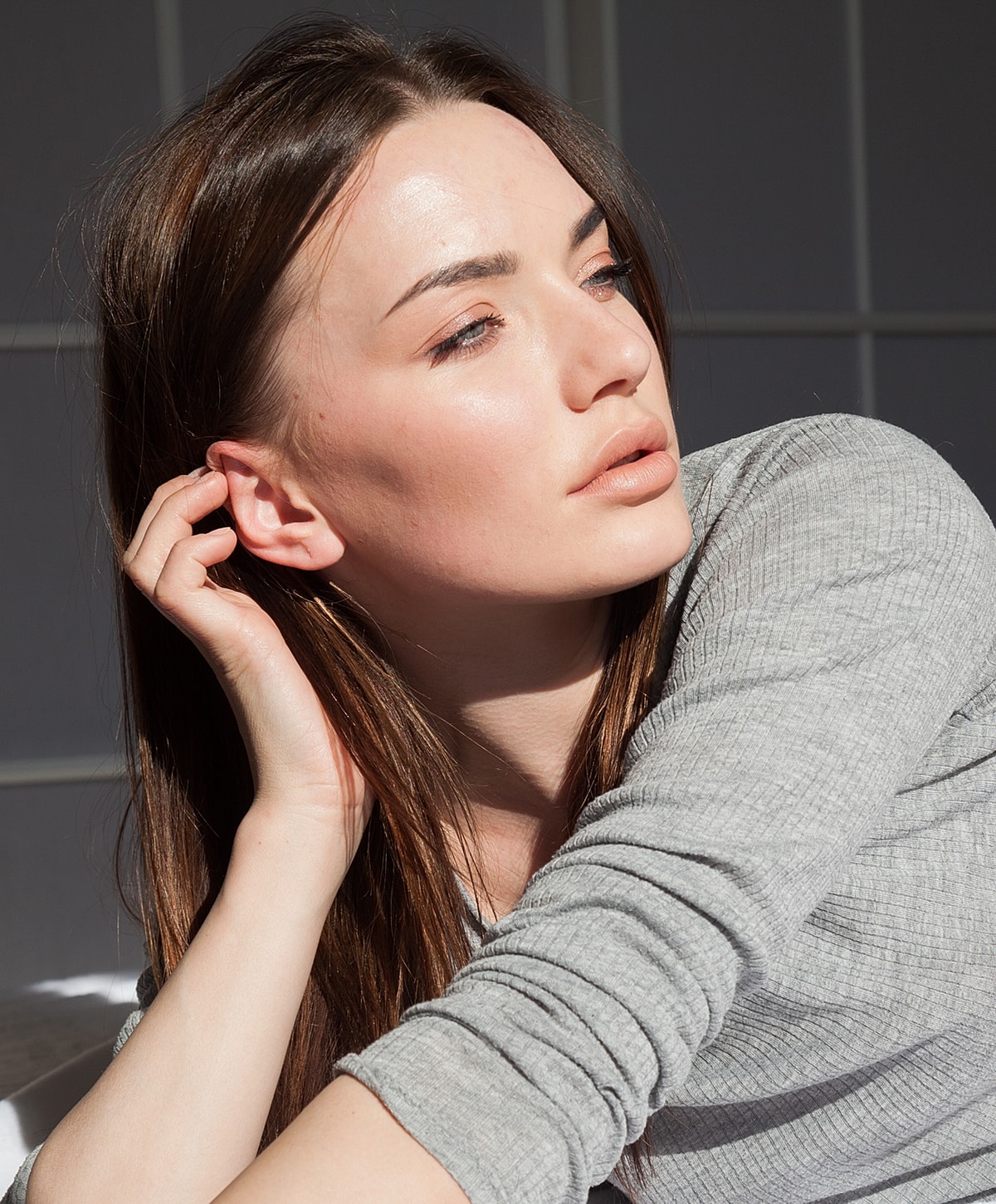 Person with natural makeup in soft lighting.