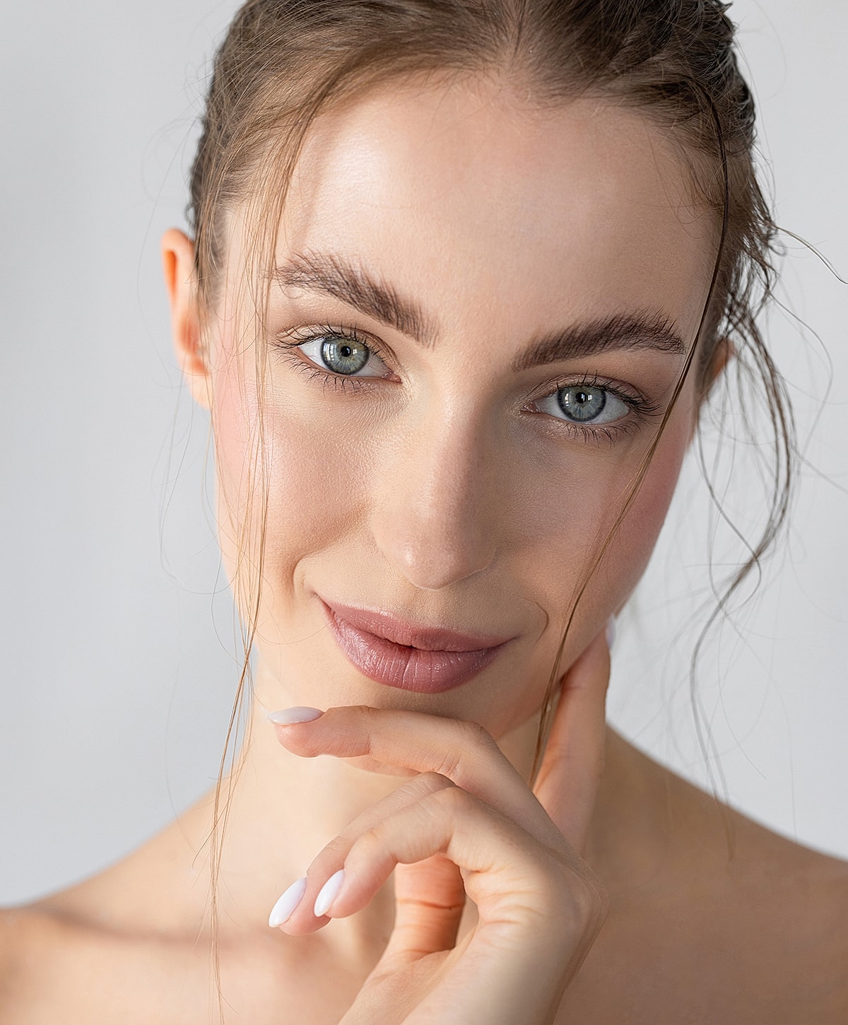 Smiling woman with natural makeup and soft features.