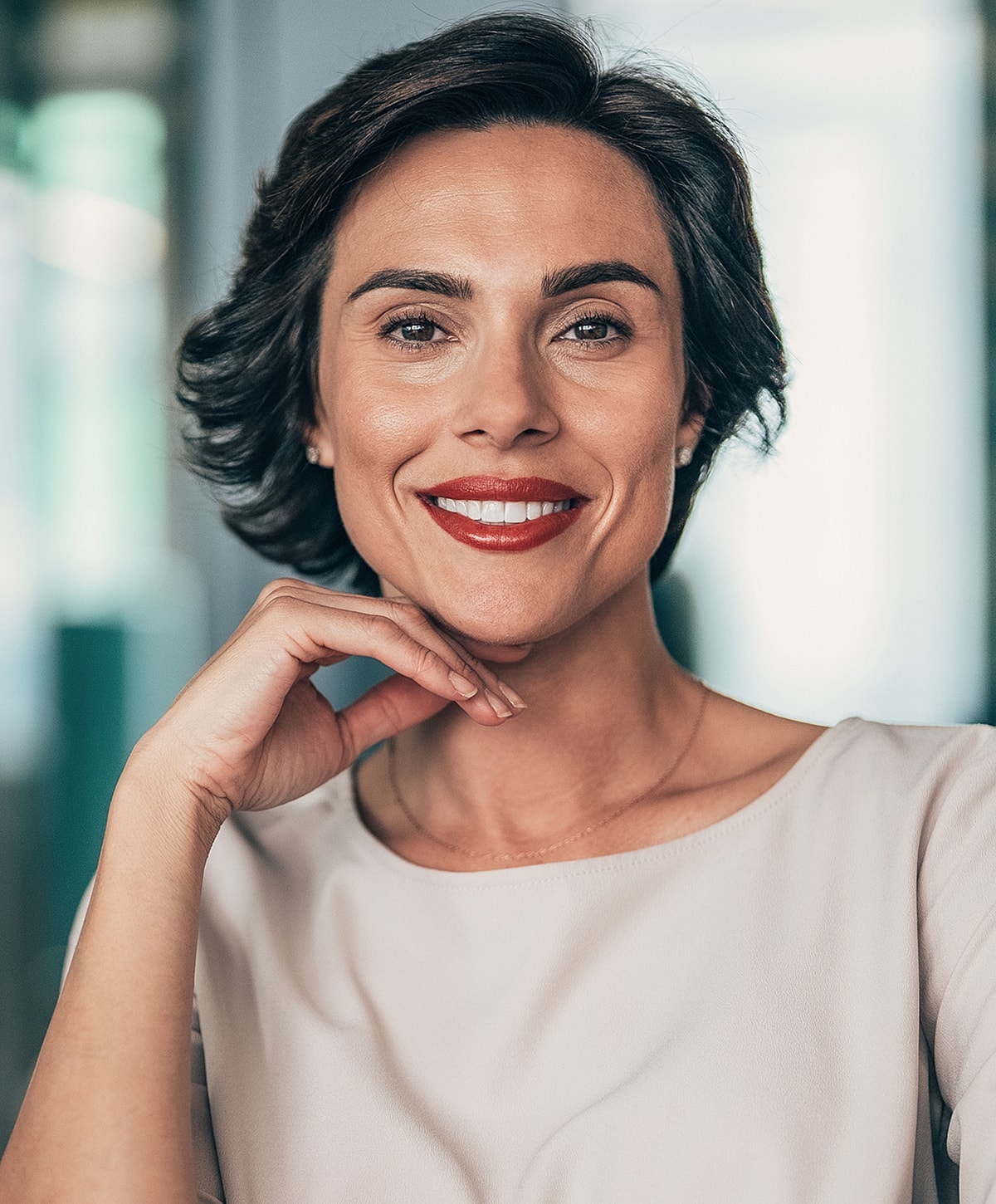 Smiling woman with short hair and red lipstick.