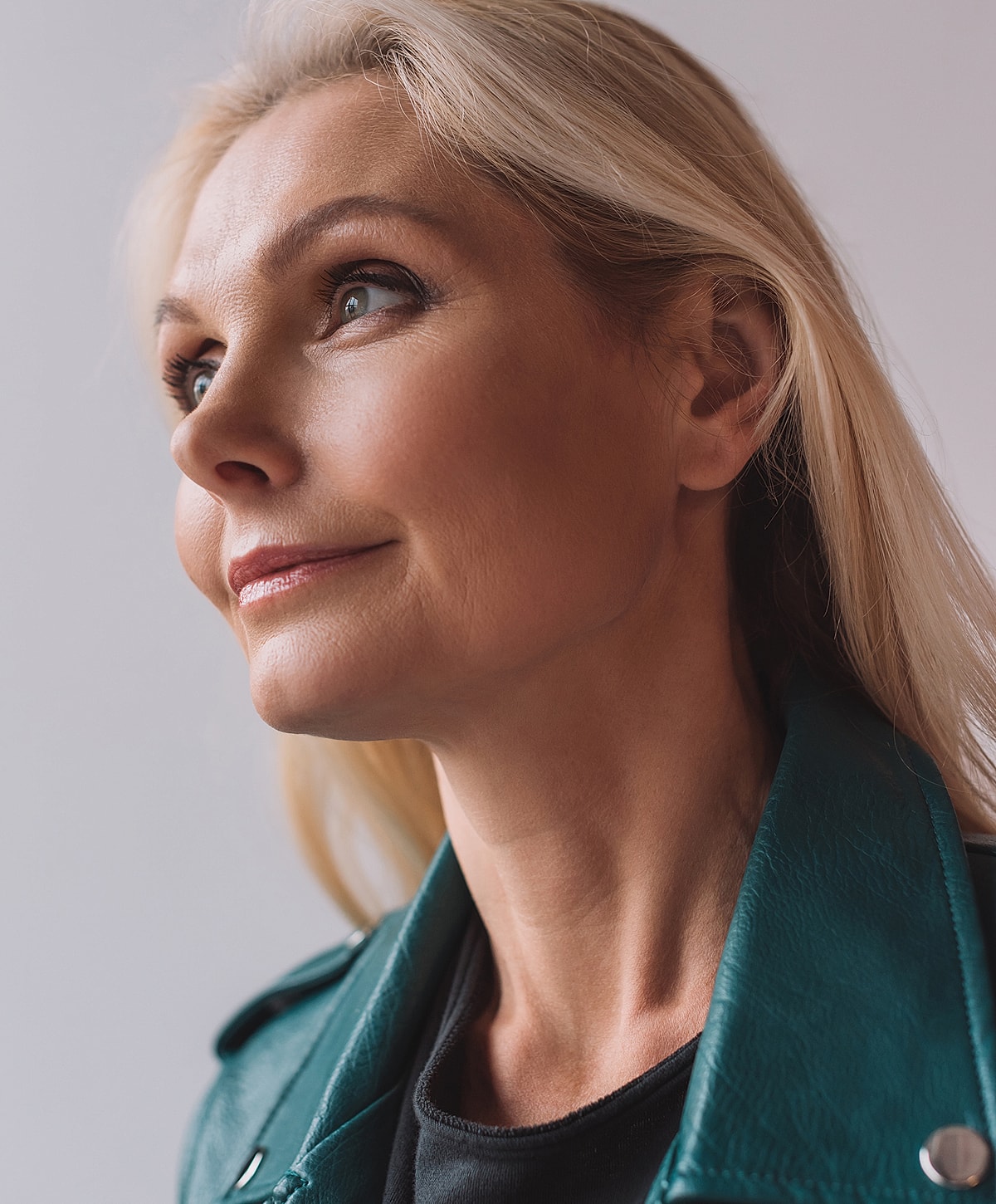 Woman with blonde hair and green leather jacket.