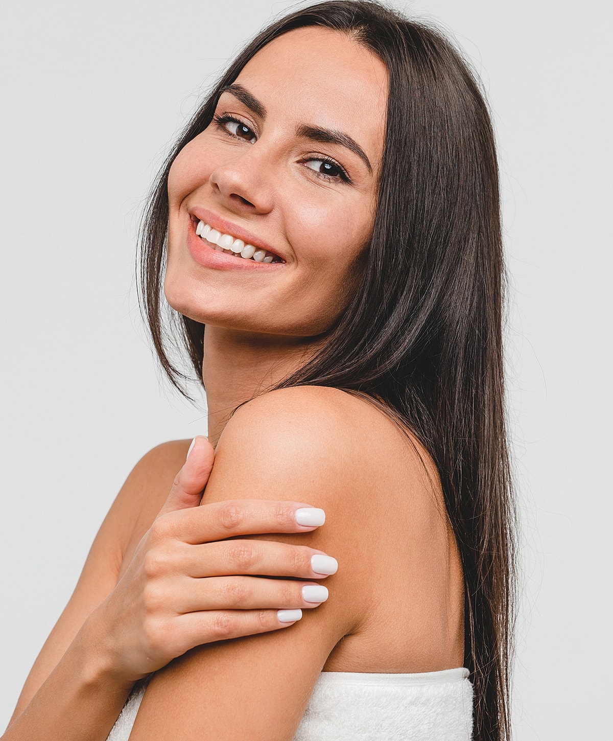 Smiling woman with long hair and white nails.