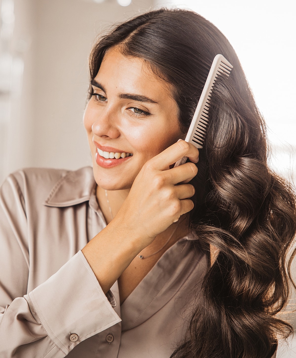Woman combing her beautiful wavy hair.