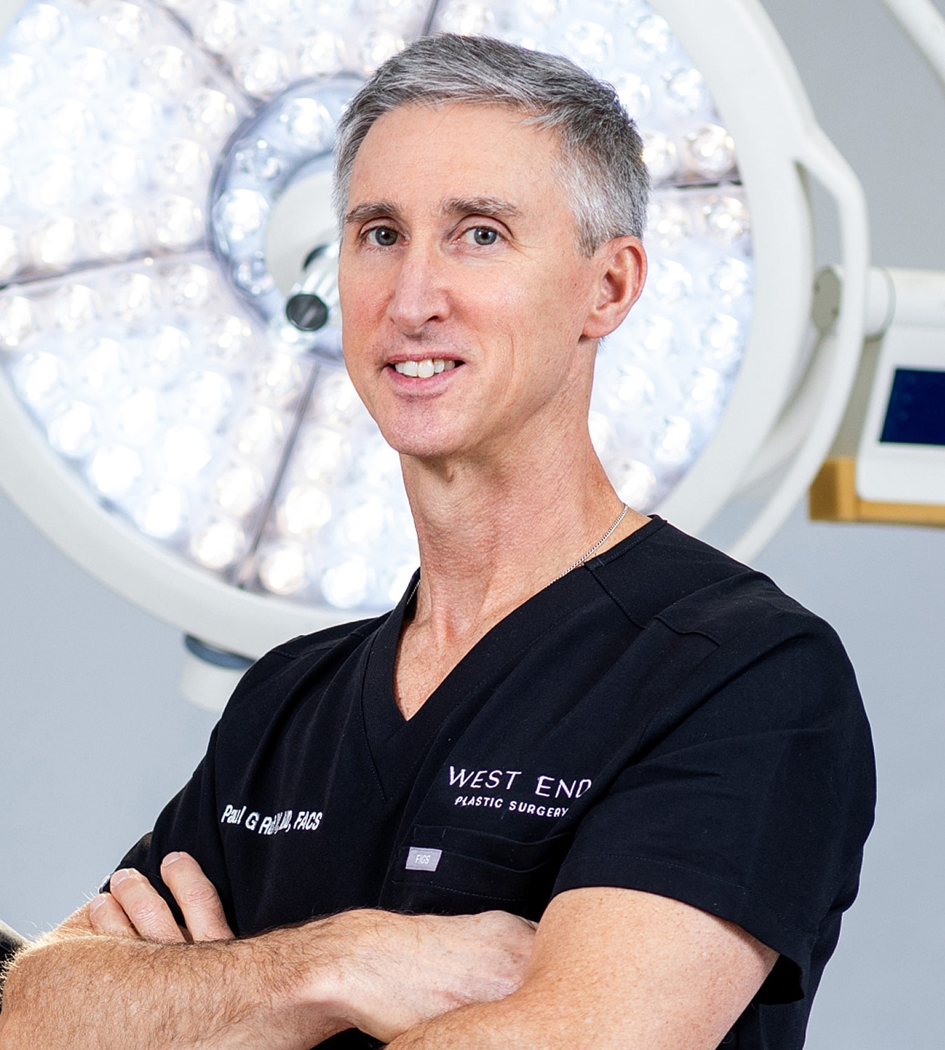 Male surgeon in operating room with surgical lights.