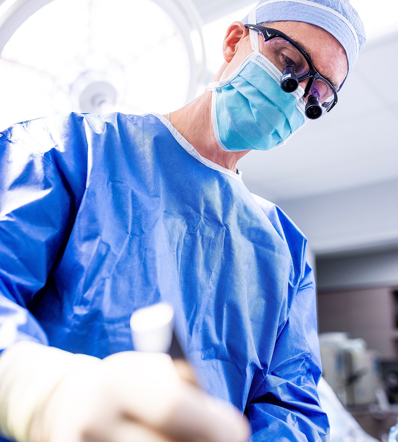 Surgeon performing a procedure in an operating room.