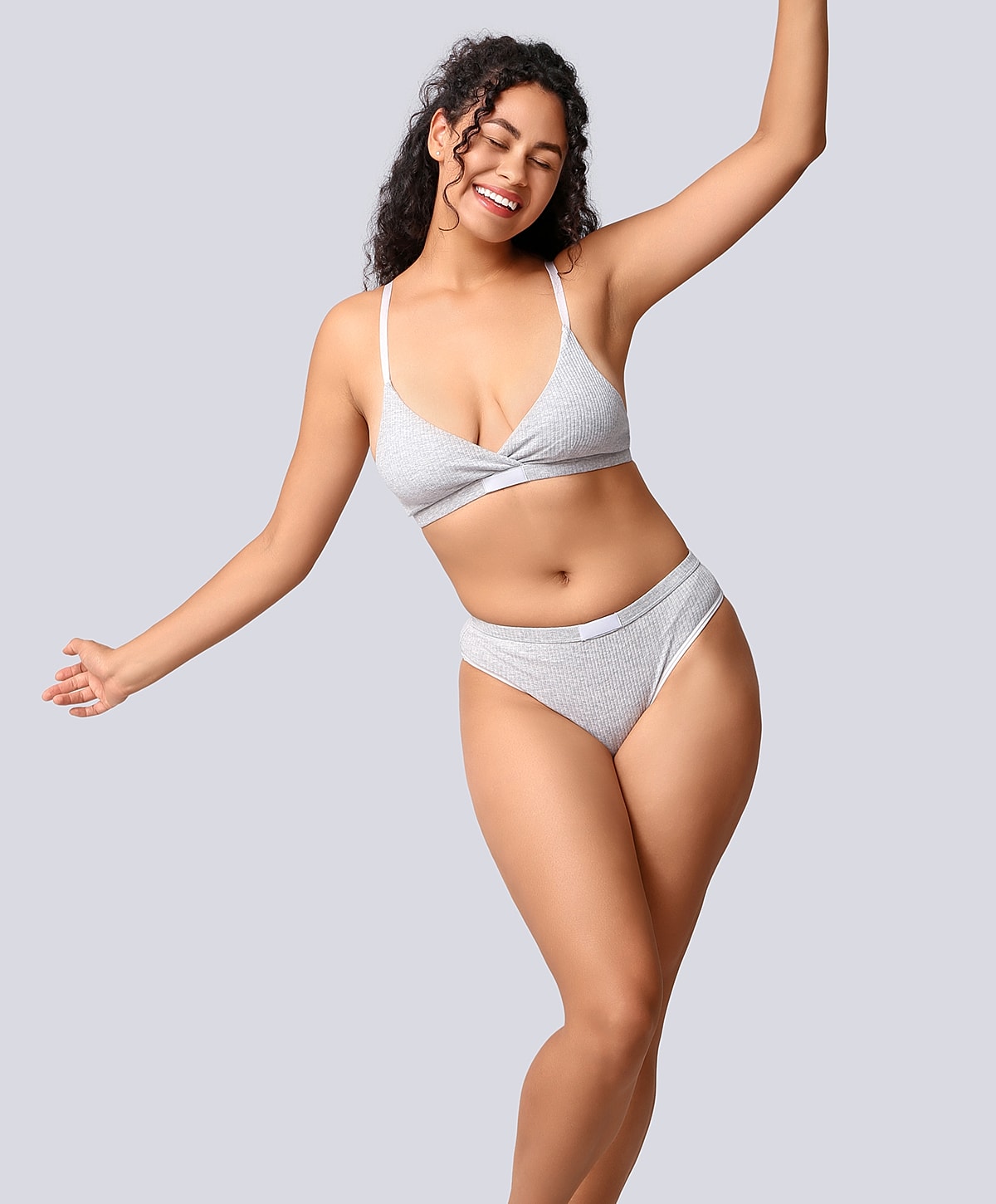 Model in stylish gray lingerie, smiling confidently.