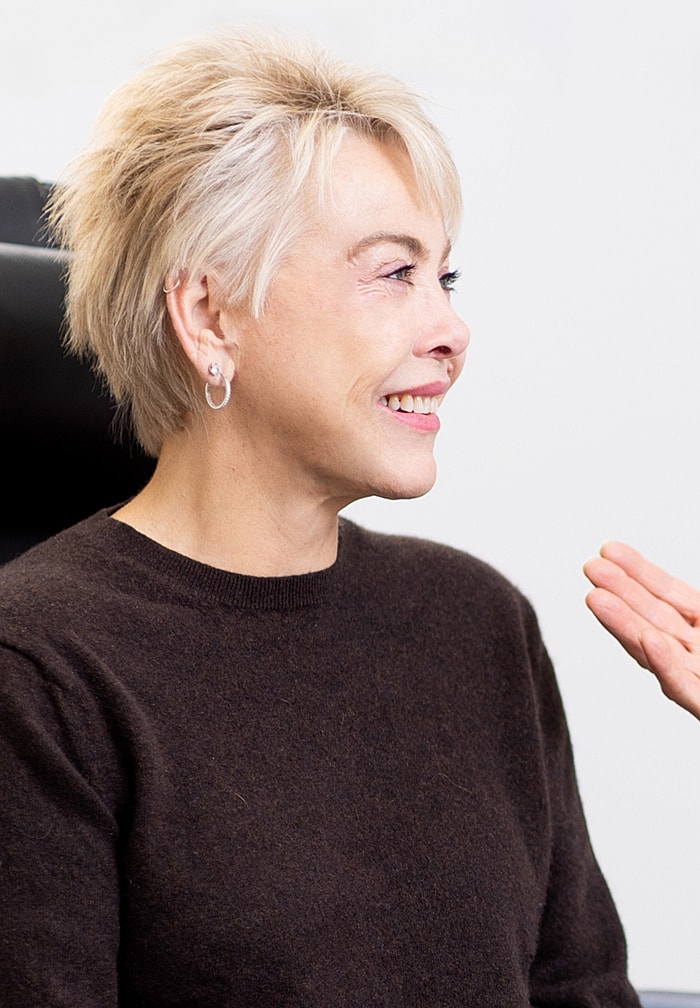 Smiling woman with short hair in conversation.