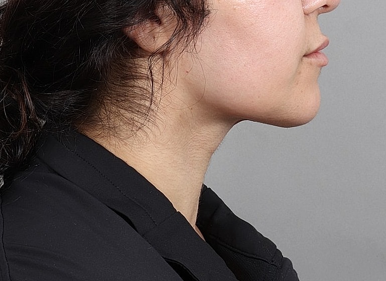 Woman's profile with natural makeup, neutral background.