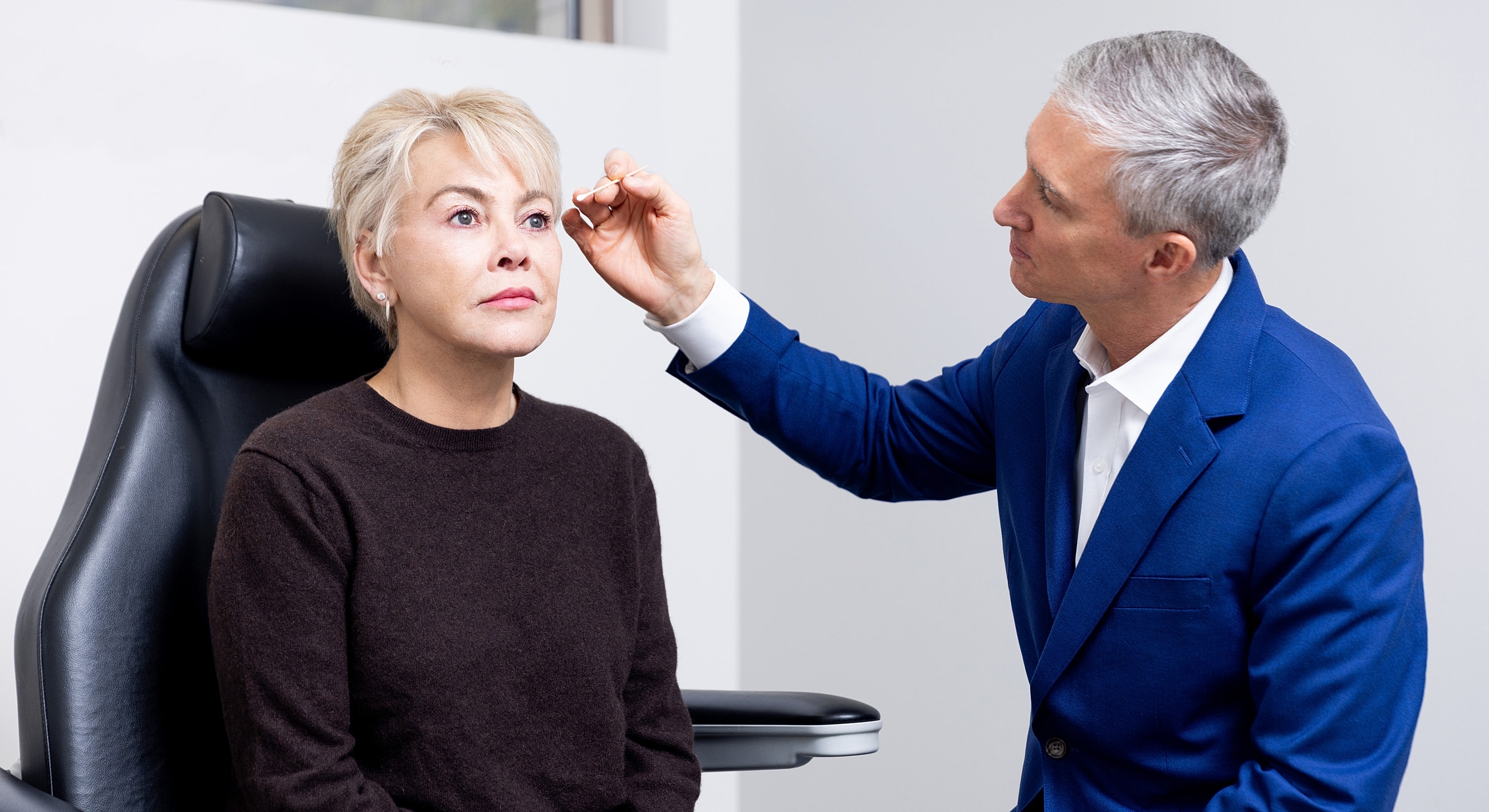 Doctor examining patient's eye in clinic.