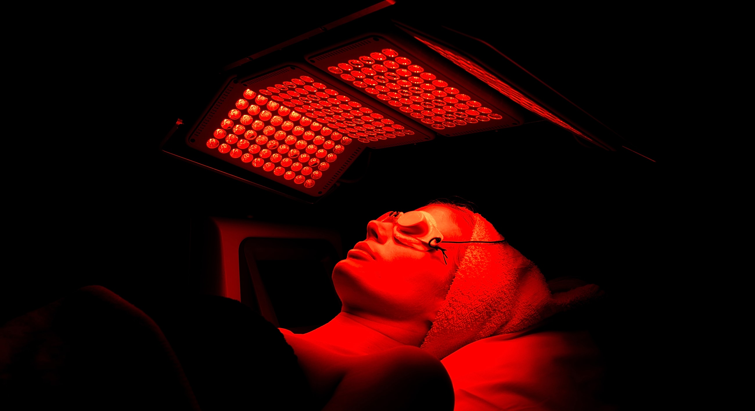 Person receiving red light therapy treatment.