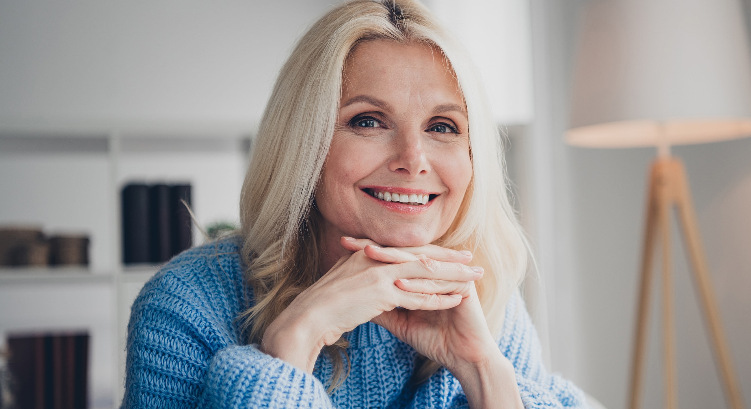Smiling woman in blue sweater at home