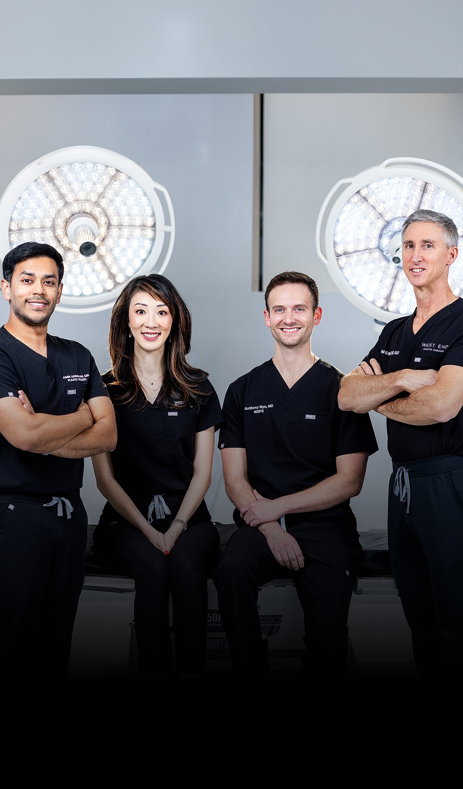 Medical professionals posing in surgical environment.