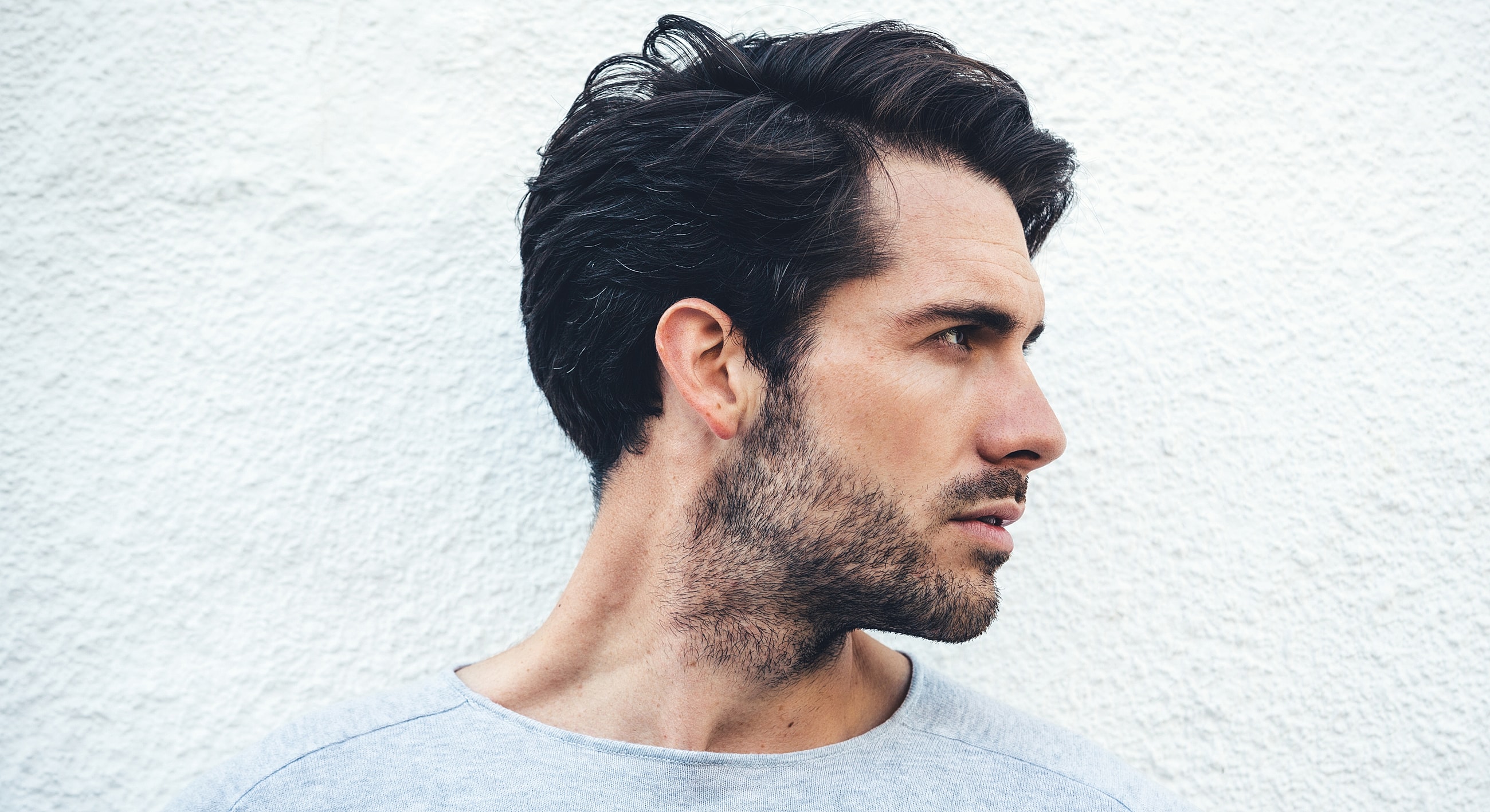 Profile of a man against a white wall.
