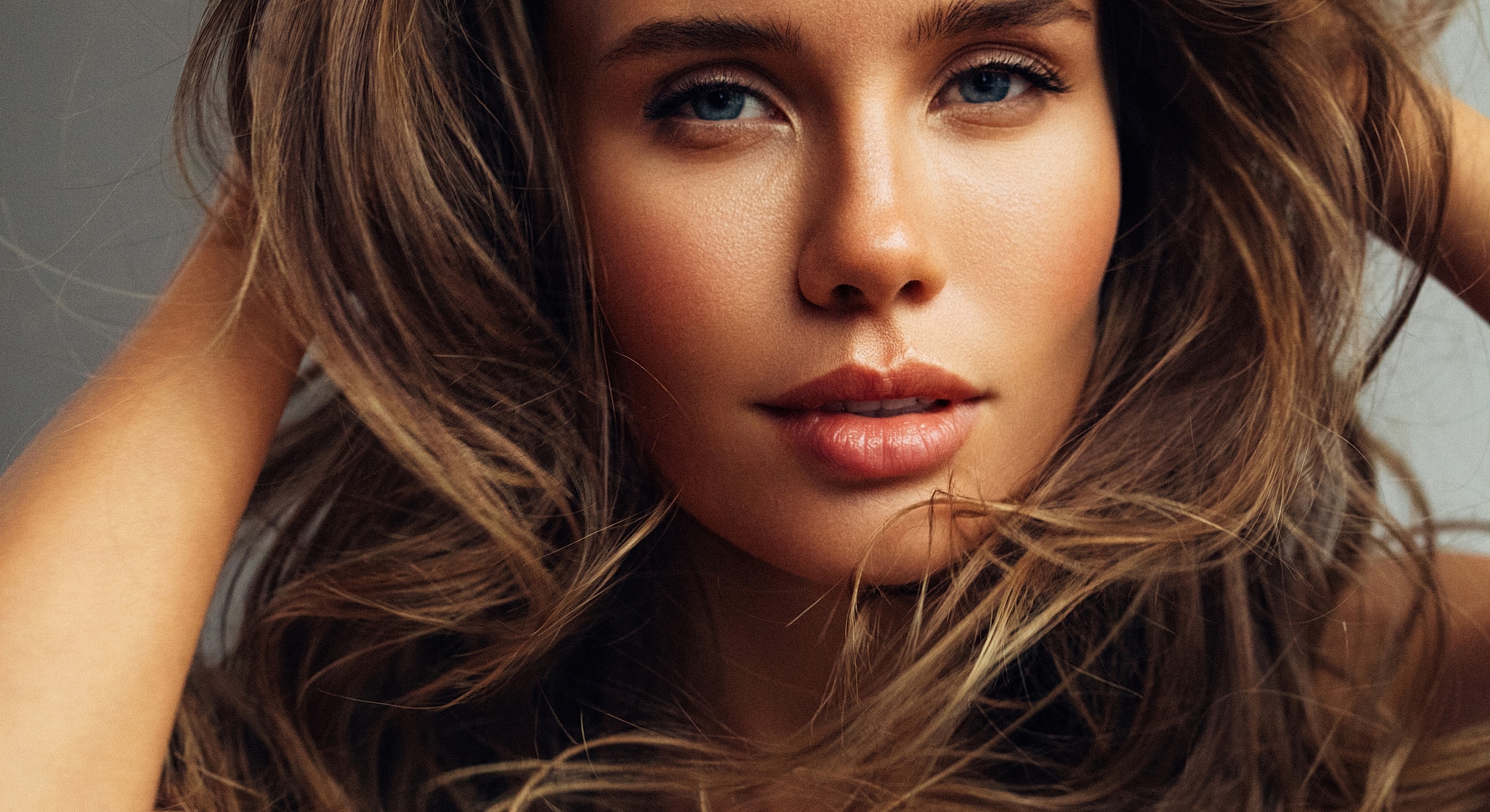 Close-up portrait of a woman with flowing hair.