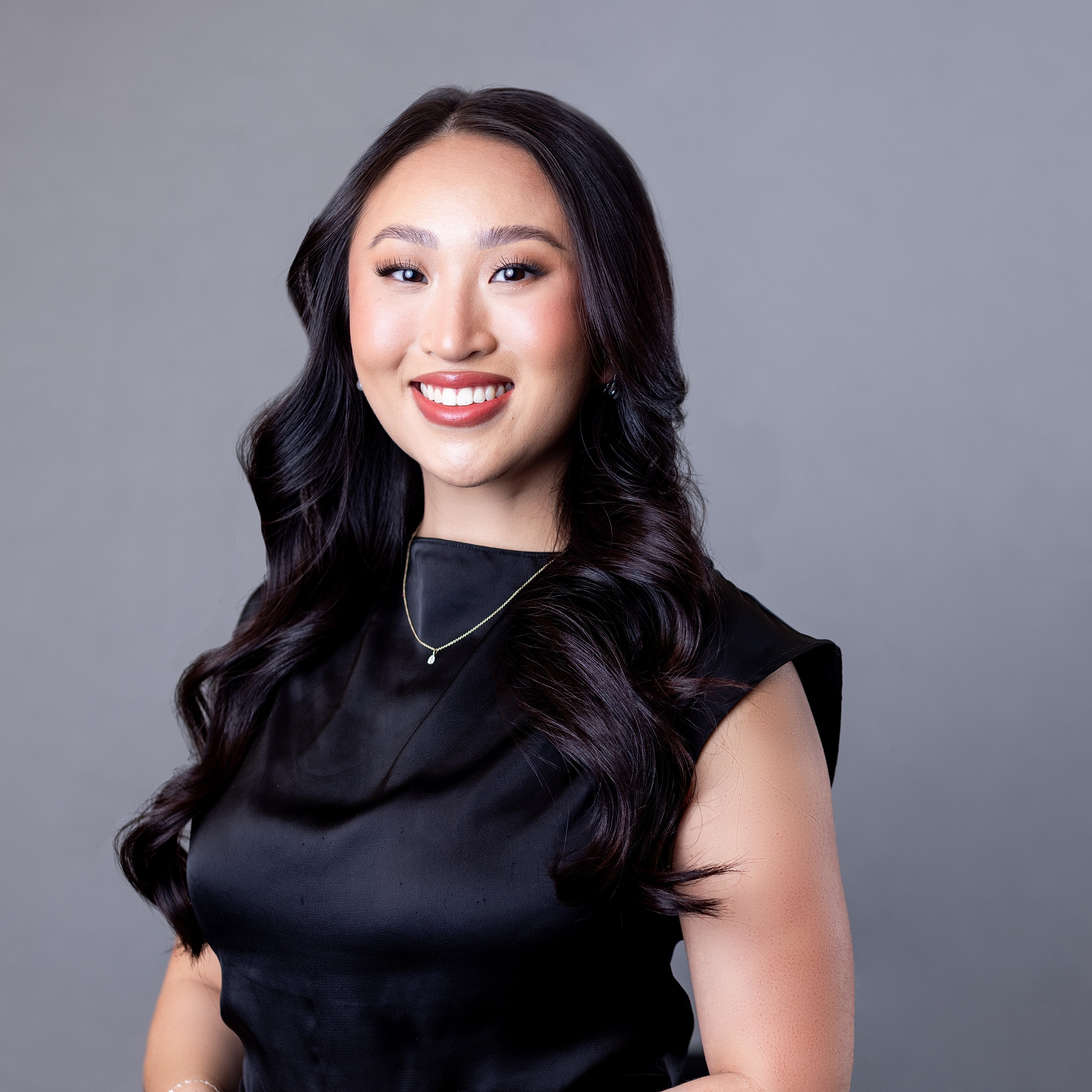 Smiling woman in a black dress portrait.