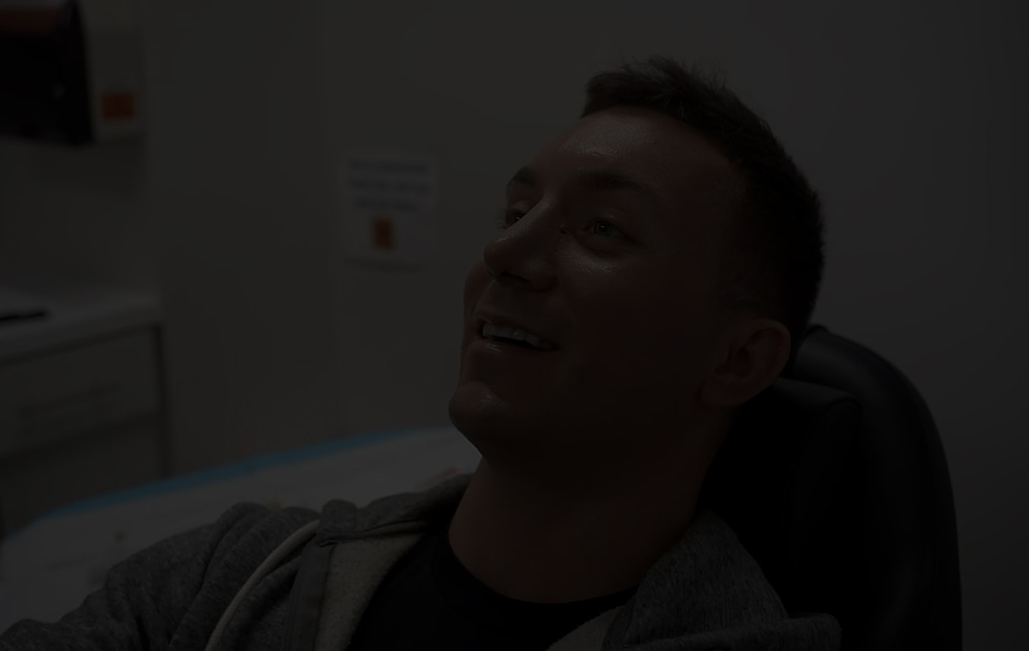 Person smiling in a dental chair.