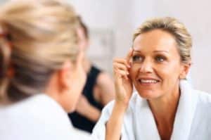 woman looking at her face after Sculptra