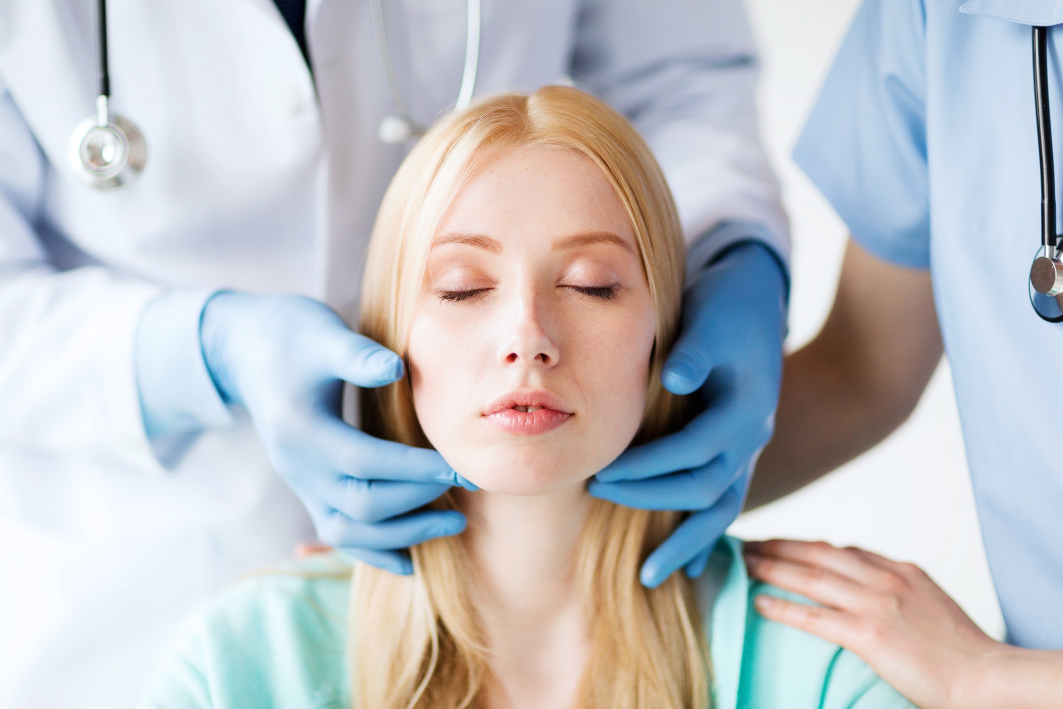 healthcare, medicine and people concept - surgeon or doctor checking up patient lymph nodes
