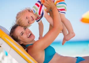 Portrait of mother playing with baby on beach